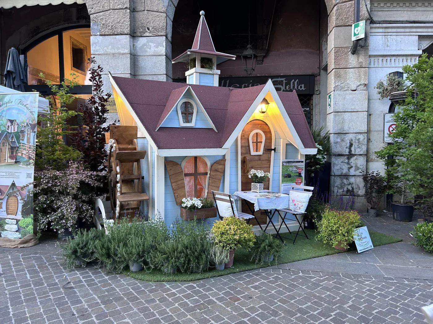 Casetta esposta a una fiera di fiori e piante nel centro storico.