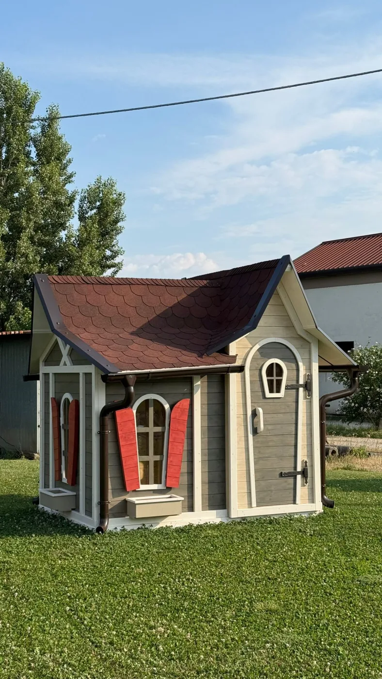 Casetta a tenda con il tetto sollevato, scaletta a pioli sul comignolo e finestra ad arco dorata, vista laterale.